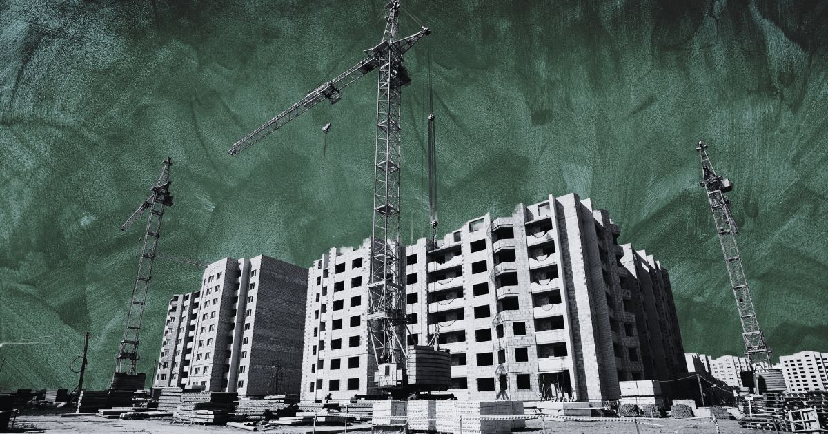 Construction site with multi-story buildings, cranes, and scattered materials; dramatic green sky. For article on 2024 U.S. apartment boom.